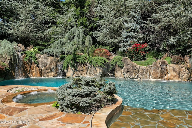 outdoor pool featuring an in ground hot tub