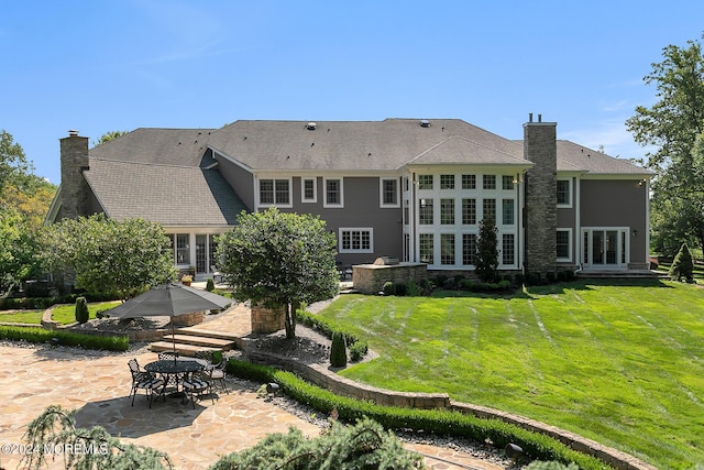 back of house with a yard, a chimney, and a patio area