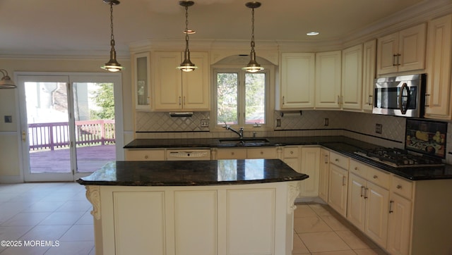 kitchen featuring stainless steel microwave, a sink, crown molding, gas stovetop, and backsplash