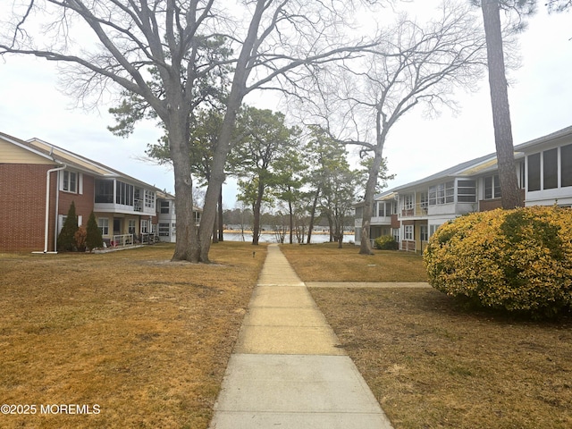 view of home's community featuring a yard, a water view, and a residential view