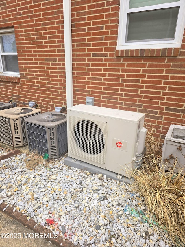 details with ac unit, brick siding, and central air condition unit