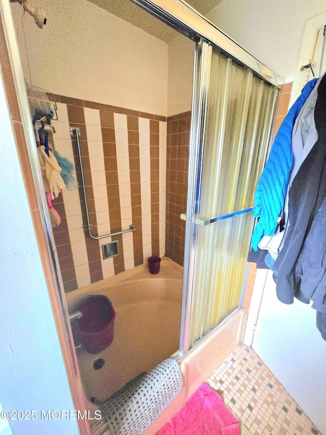 bathroom with a bathing tub, an enclosed shower, and tile patterned floors