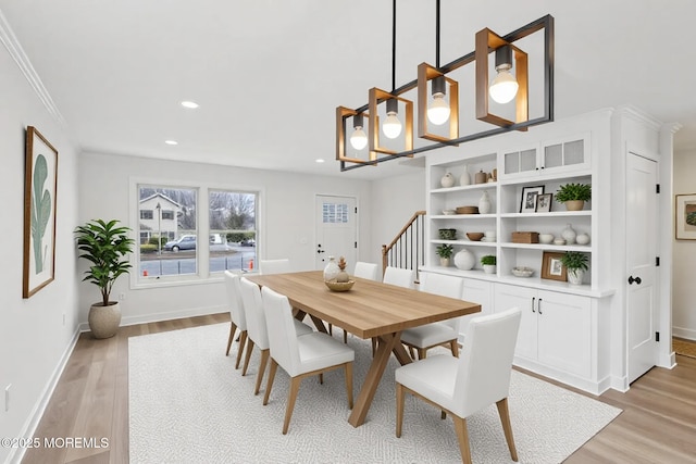 dining space featuring crown molding, recessed lighting, light wood-style flooring, baseboards, and stairs