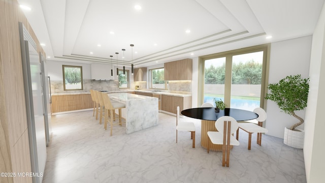 kitchen featuring marble finish floor, a tray ceiling, and a center island