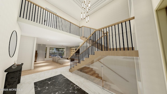 stairs with a towering ceiling and marble finish floor