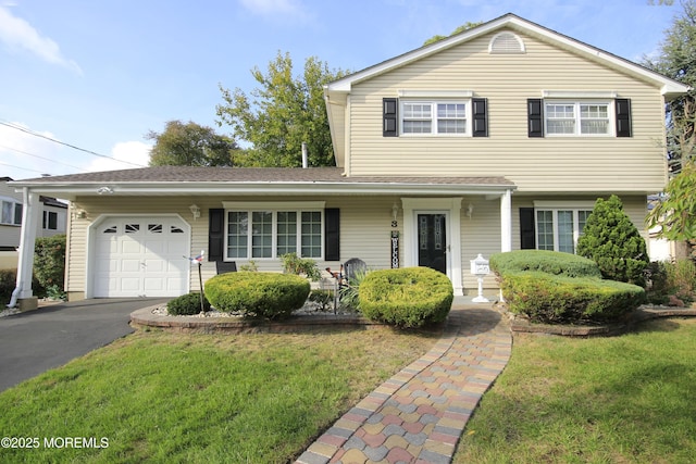 view of front facade featuring a garage, covered porch, driveway, and a front lawn