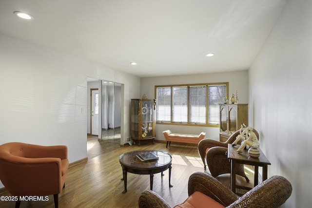 living area with recessed lighting, baseboards, and wood finished floors