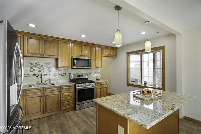 kitchen featuring appliances with stainless steel finishes, dark wood-style flooring, a sink, and brown cabinets