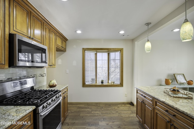 kitchen with stainless steel appliances, tasteful backsplash, visible vents, dark wood-type flooring, and light stone countertops