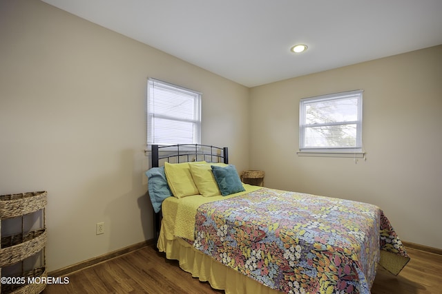 bedroom with baseboards and dark wood-type flooring