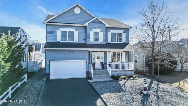 view of front of house featuring a porch, driveway, and an attached garage