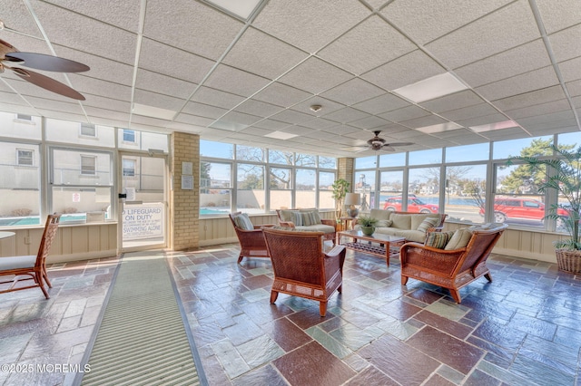 sunroom / solarium with ceiling fan, a paneled ceiling, and a healthy amount of sunlight