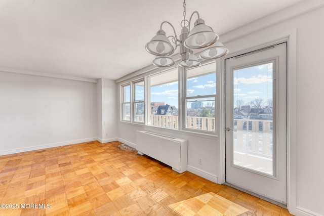 unfurnished dining area featuring baseboards, radiator heating unit, and a notable chandelier