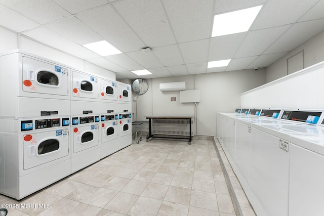 community laundry room with washer and clothes dryer, a wall mounted air conditioner, and stacked washer / drying machine