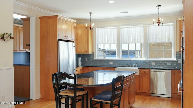 kitchen featuring visible vents, a chandelier, stainless steel appliances, and a sink