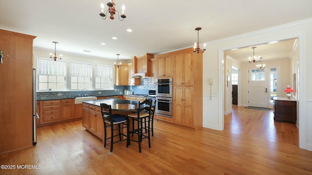 kitchen with ornamental molding, a sink, and an inviting chandelier