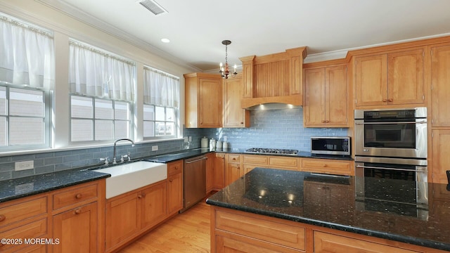 kitchen with tasteful backsplash, visible vents, appliances with stainless steel finishes, crown molding, and a sink