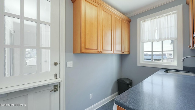 office with baseboards, a sink, and ornamental molding