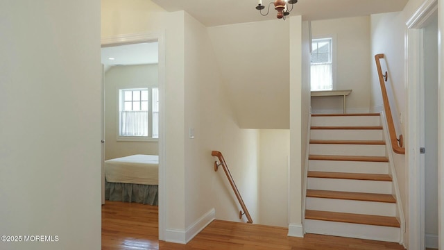 staircase featuring wood finished floors and baseboards