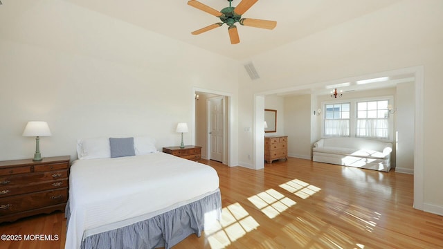 bedroom featuring high vaulted ceiling, visible vents, light wood-style flooring, and baseboards