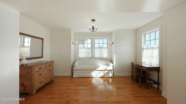 living area with light wood-style floors, plenty of natural light, and baseboards