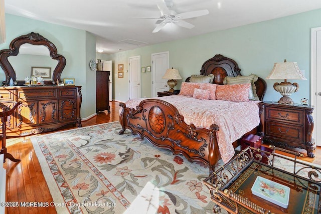 bedroom featuring attic access, ceiling fan, and hardwood / wood-style floors