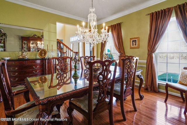 dining room with baseboards, ornamental molding, wood-type flooring, and a notable chandelier