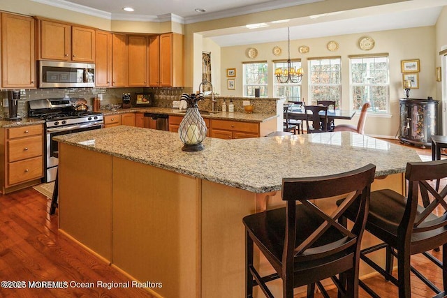 kitchen with stainless steel appliances, dark wood-style flooring, a sink, and tasteful backsplash