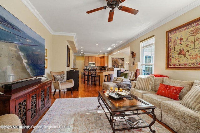 living area with ceiling fan, recessed lighting, wood finished floors, and crown molding