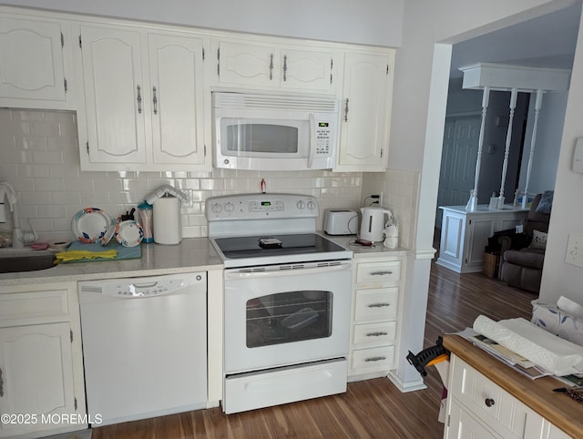 kitchen with white appliances, a sink, white cabinets, light countertops, and dark wood-style floors