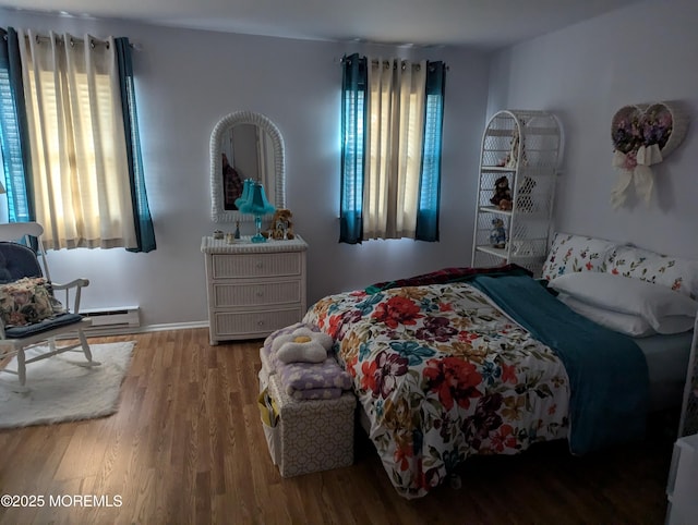 bedroom featuring a baseboard radiator and wood finished floors