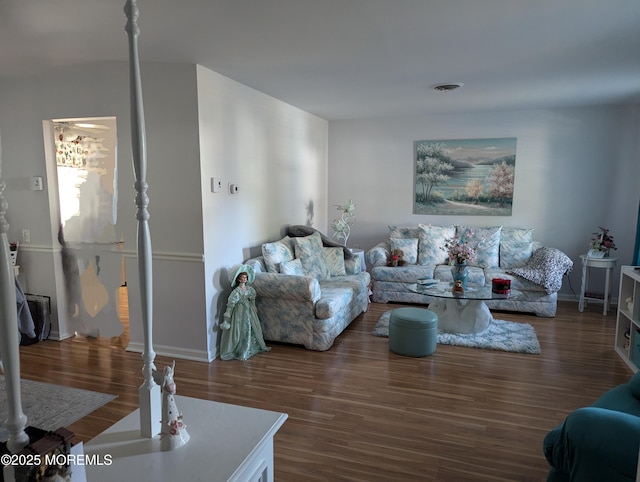 living room with baseboards, visible vents, and wood finished floors