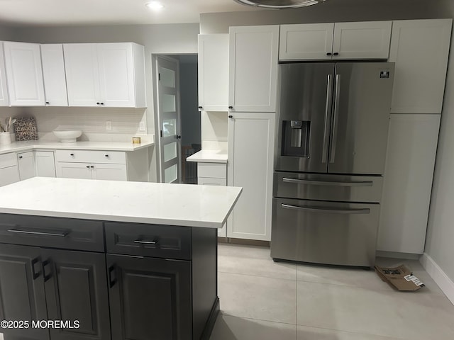 kitchen featuring light tile patterned floors, tasteful backsplash, white cabinetry, and stainless steel fridge with ice dispenser