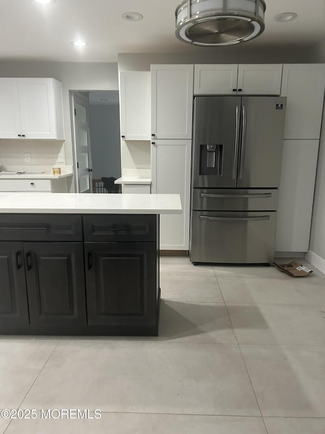 kitchen featuring recessed lighting, stainless steel fridge with ice dispenser, light countertops, white cabinetry, and light tile patterned flooring