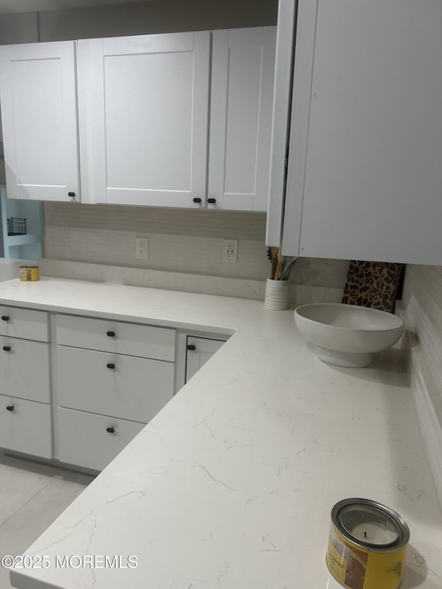 kitchen featuring white cabinets and light stone countertops