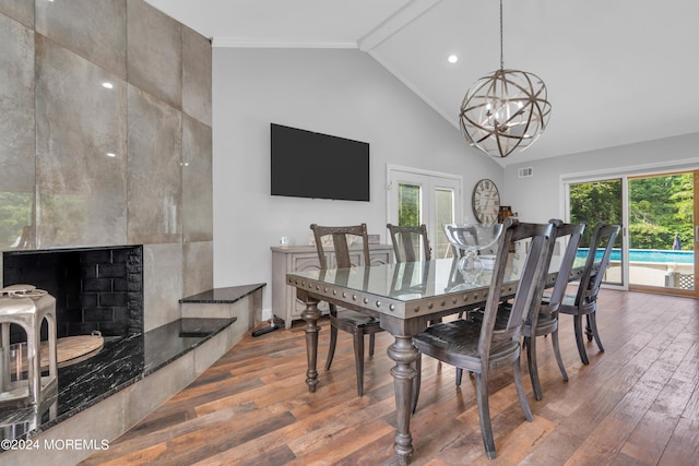 dining space with high vaulted ceiling, ornamental molding, hardwood / wood-style flooring, and a notable chandelier