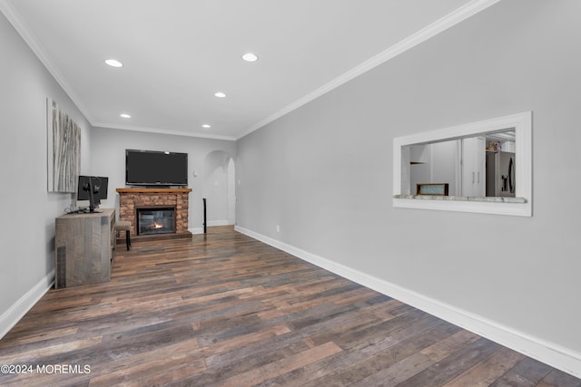 living area with arched walkways, crown molding, recessed lighting, wood finished floors, and baseboards