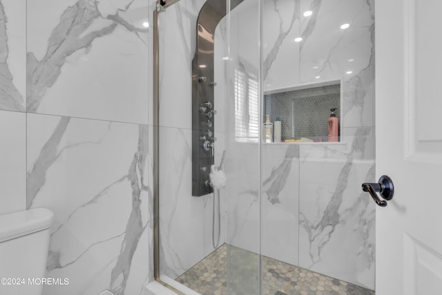 full bath featuring toilet and a marble finish shower