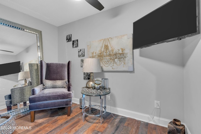 living area with a ceiling fan, baseboards, and wood finished floors