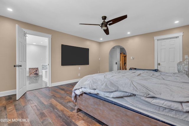 bedroom with arched walkways, recessed lighting, wood finished floors, and baseboards