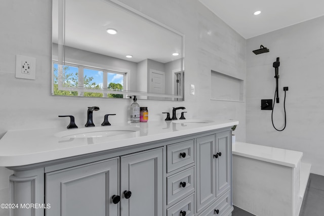 full bathroom with double vanity, recessed lighting, a sink, and tiled shower