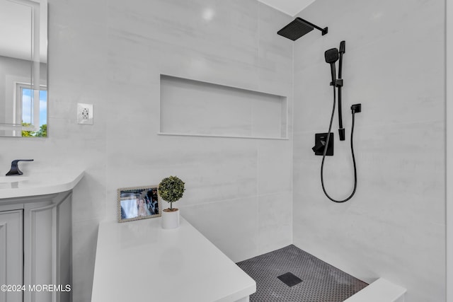 bathroom featuring tiled shower and vanity