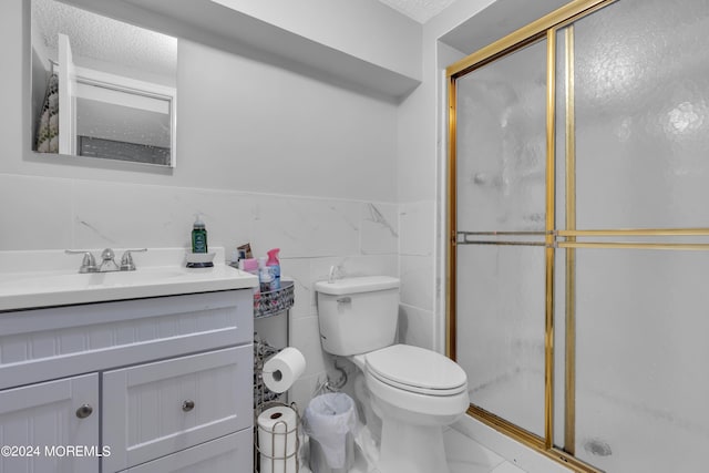 bathroom with toilet, a stall shower, a textured ceiling, and vanity