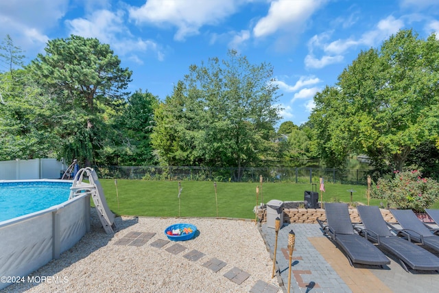 view of pool featuring a fenced in pool, a fenced backyard, a lawn, and a patio