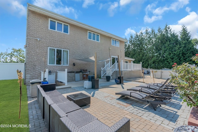 back of house featuring exterior kitchen, an outdoor fire pit, a patio area, and fence