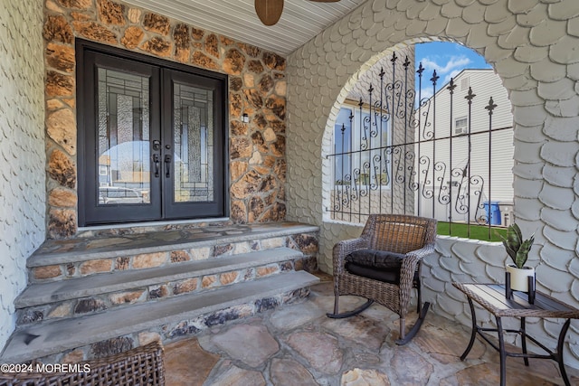 property entrance featuring stone siding, french doors, and a ceiling fan