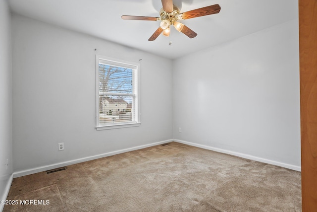 carpeted empty room with a ceiling fan, visible vents, and baseboards