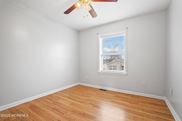 spare room featuring light wood-style flooring, visible vents, ceiling fan, and baseboards