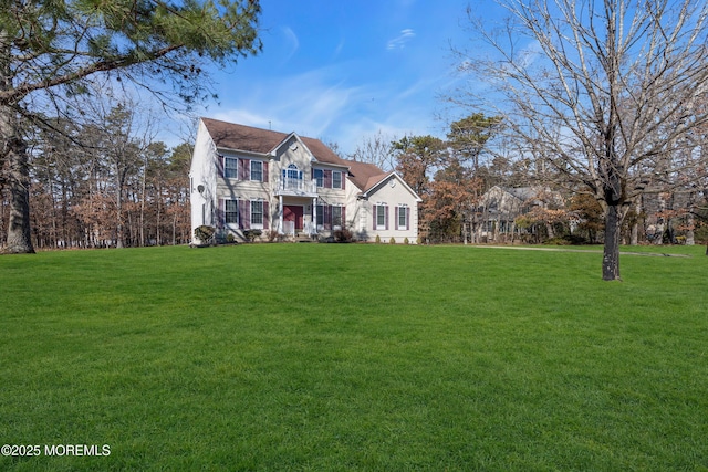 view of front of house featuring a front lawn and a balcony