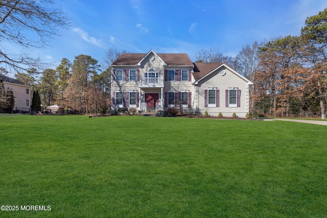 view of front of home with a front yard and a balcony